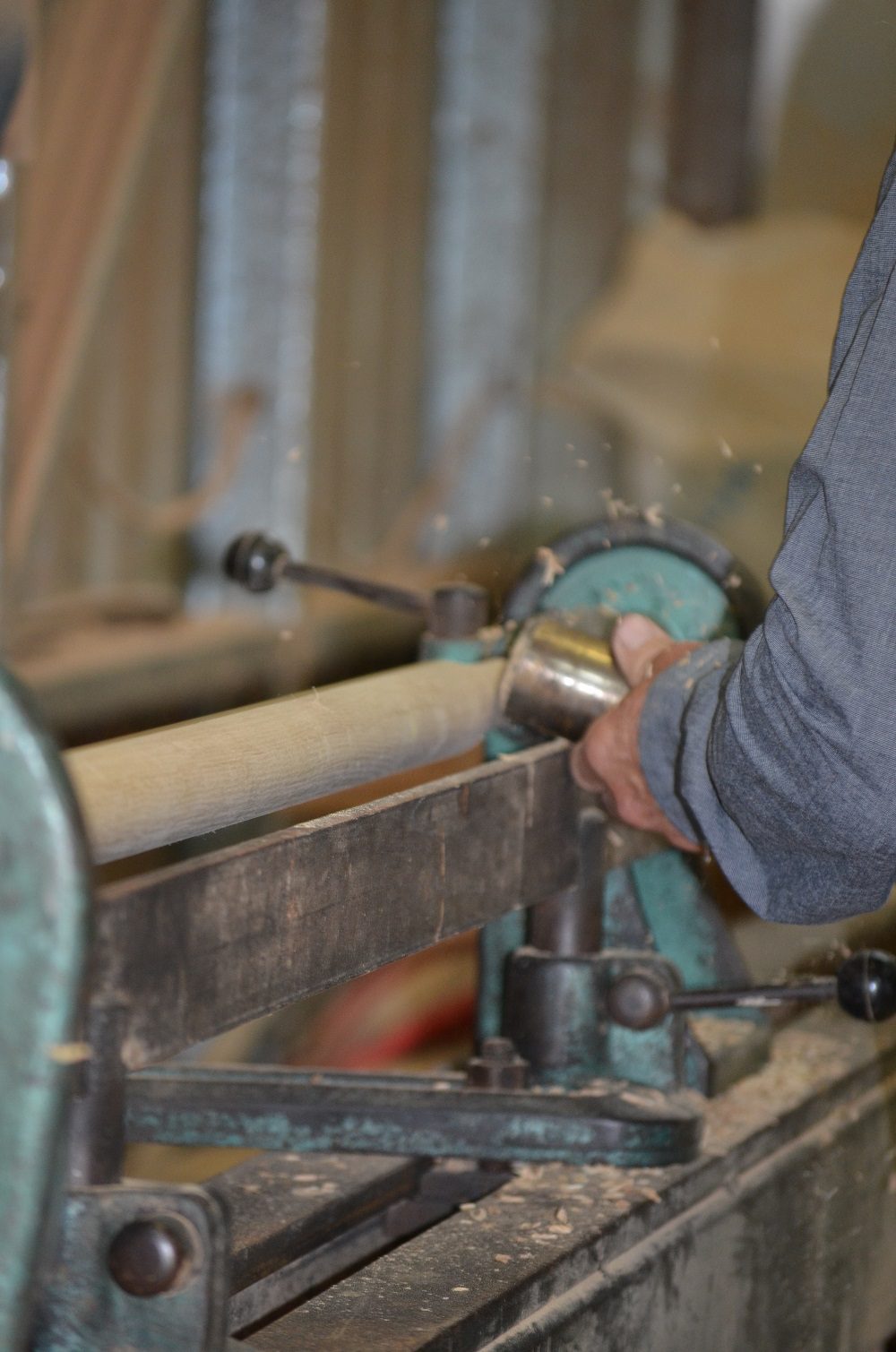 Craftsman operating a woodturning lathe to shape timber staircase components