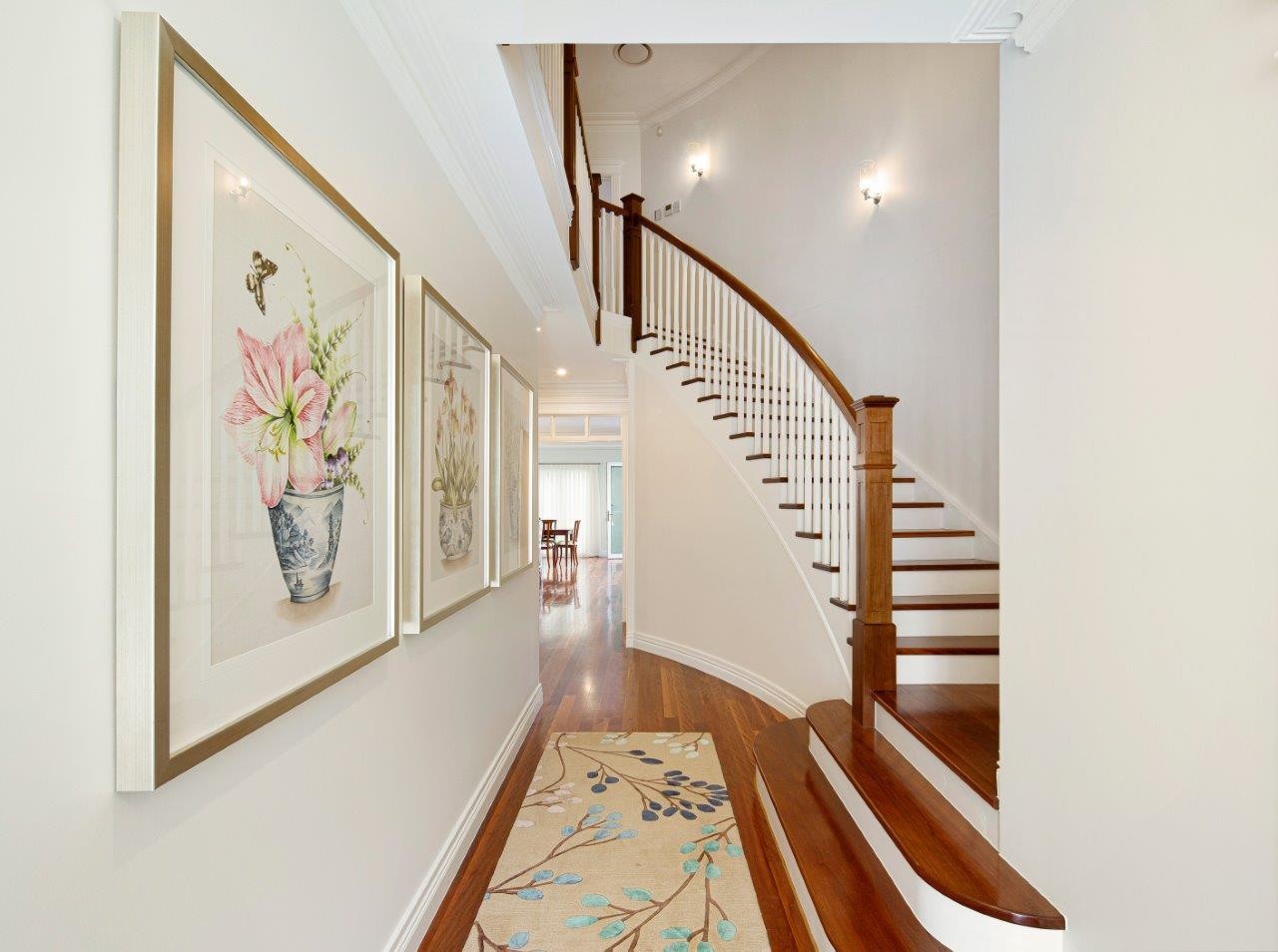 Grand curved traditional staircase with hardwood treads and white balustrade