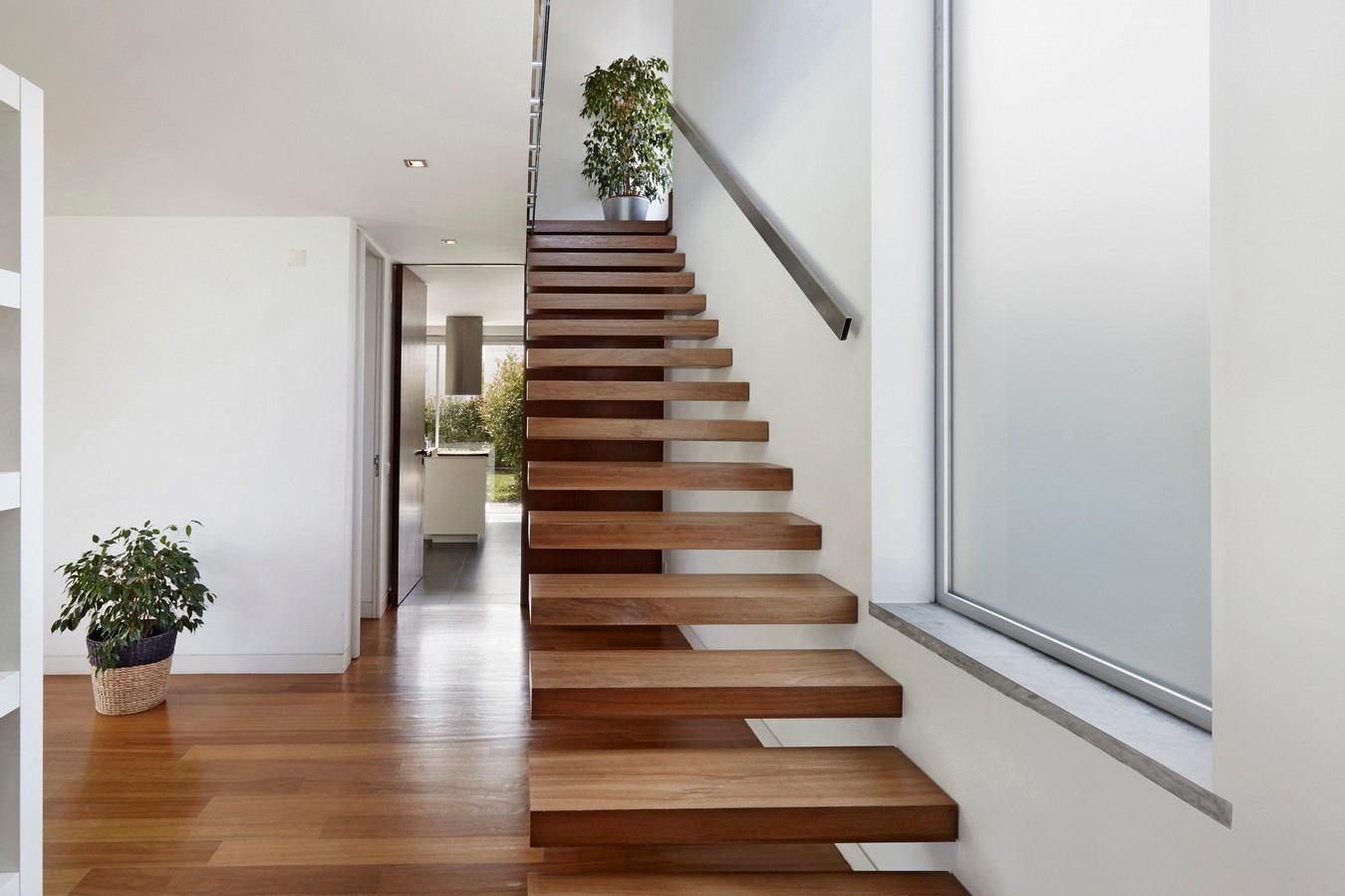Floating timber staircase with cantilevered treads and glass balustrade in a modern Brisbane home