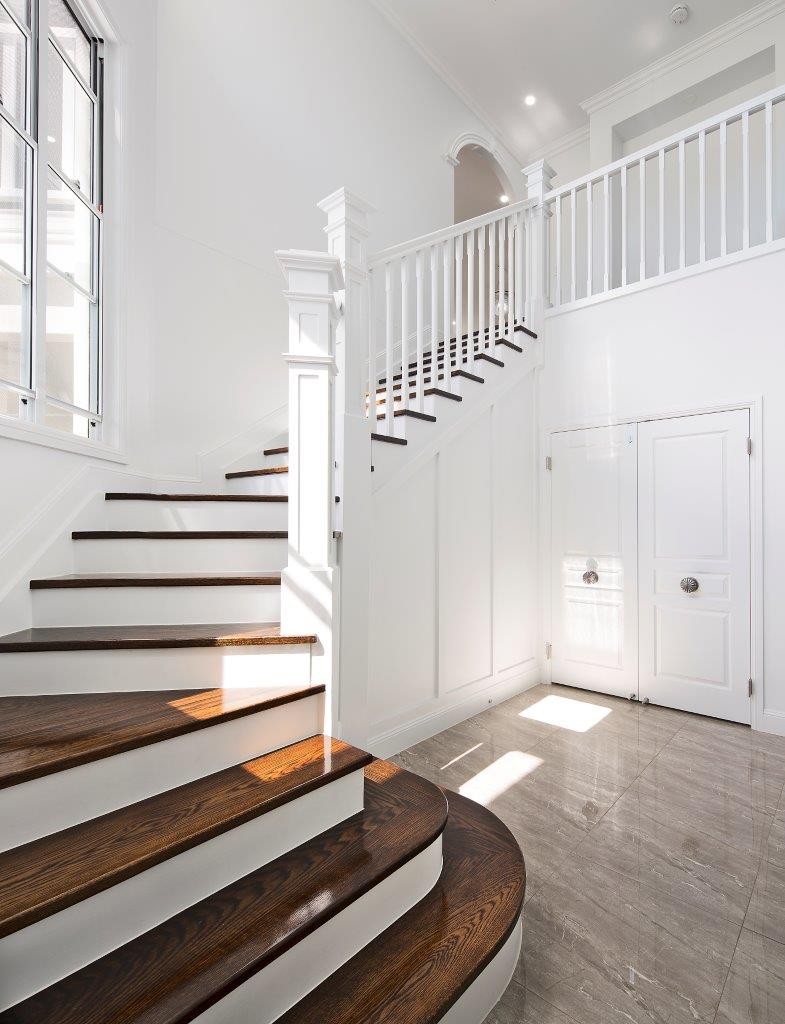 Top-down view of ornate wrought iron balustrade with timber handrail on spiral staircase
