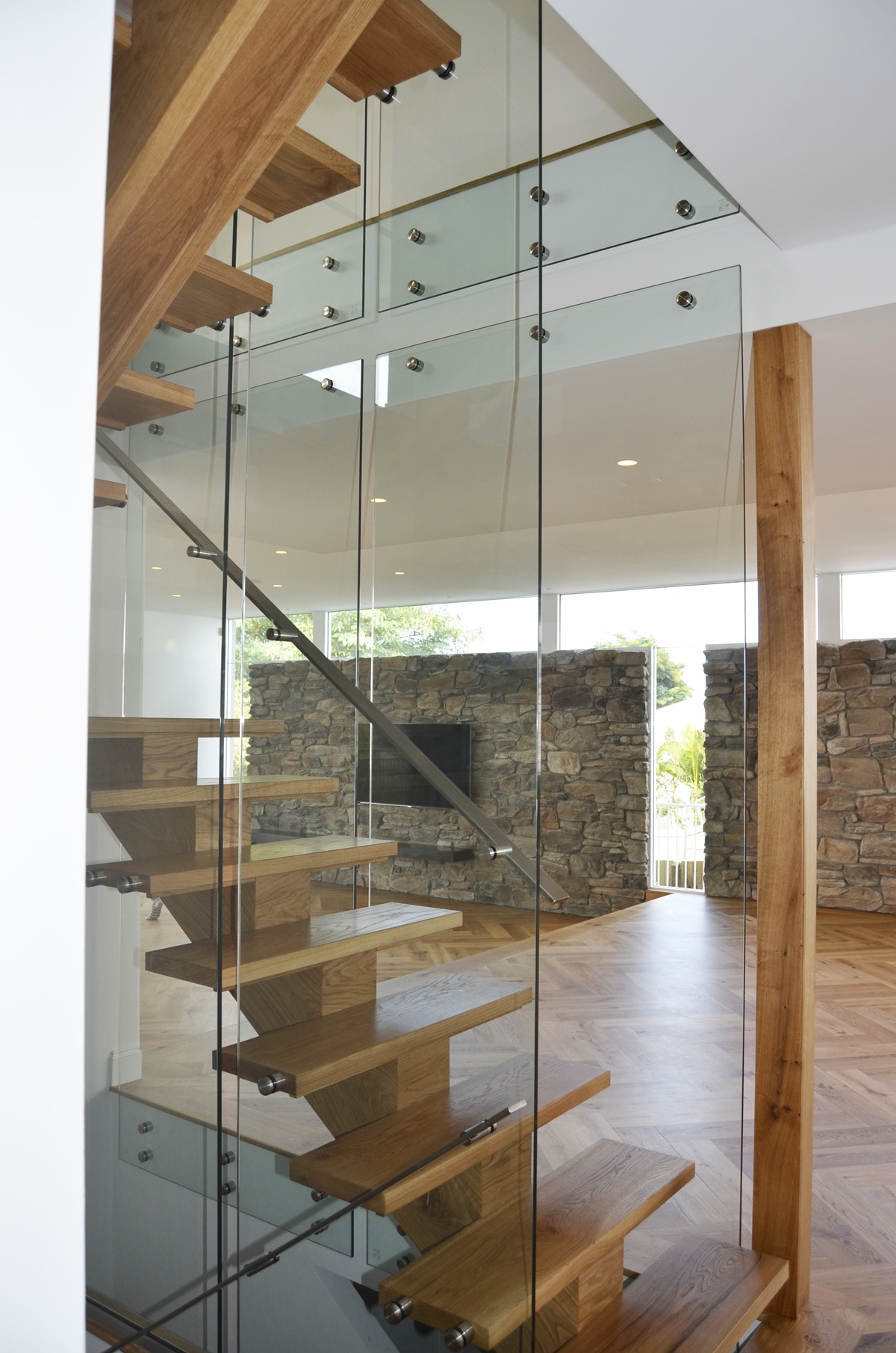 Curved internal timber staircase with steel balustrade in a modern Brisbane home