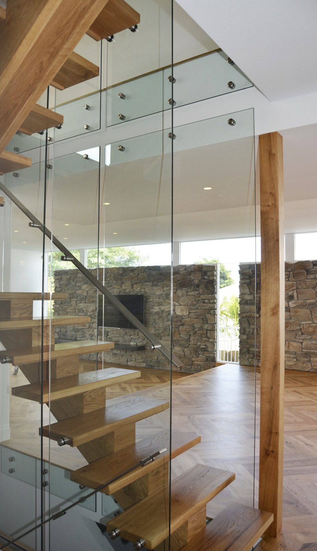 Architectural floating staircase with sculptural timber treads in a luxury Australian home