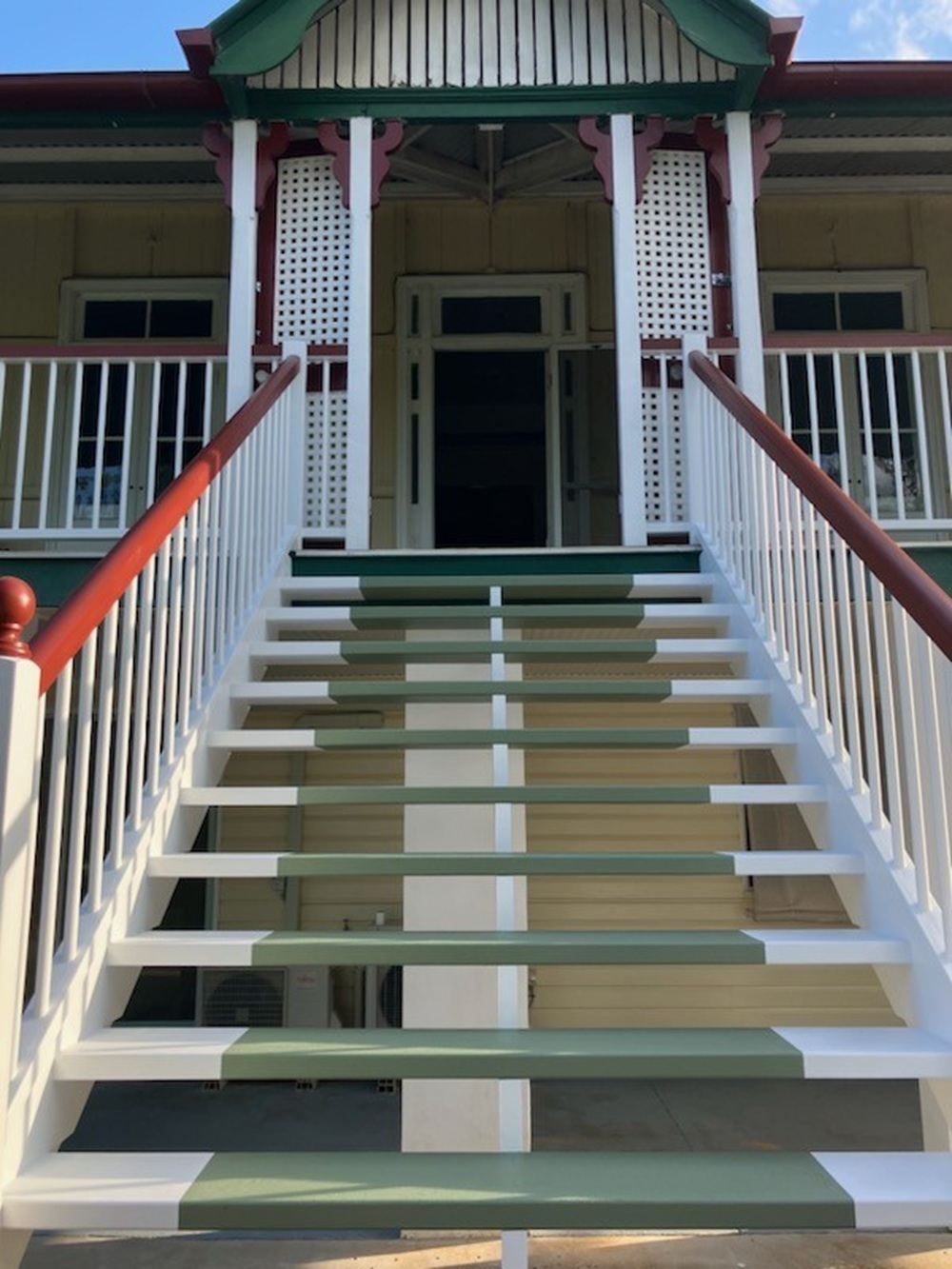 Painted external stairs on a Queenslander with green surrounds