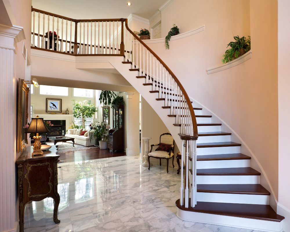 Luxurious curved hardwood staircase with ornate balustrade in a grand Brisbane home