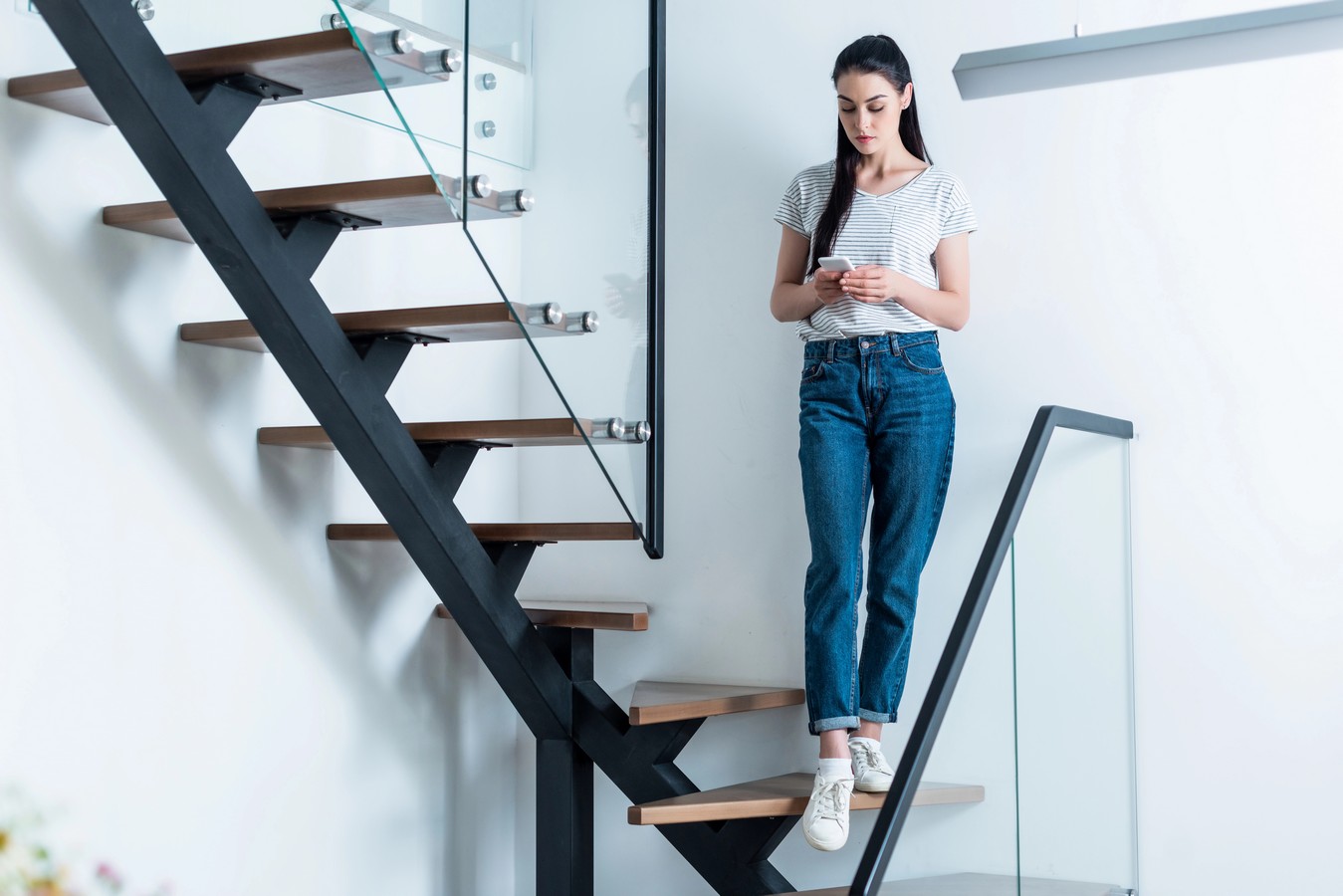 Woman descending a steel stringer staircase with timber treads
